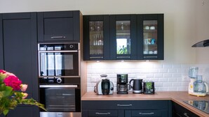 A modern kitchen with a built-in oven, coffee maker, and toaster. - Les Clés de Censibele - Charmant gîte pour 12 (Braye)