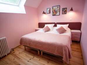 Ein Schlafzimmer mit einem Bett, zwei Nachttischen, einer Heizung und einem Fenster.