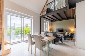 Ein modernes Interieur mit Essbereich, Wohnbereich und Treppe.