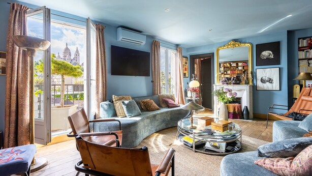 Ein geräumiges Wohnzimmer mit einer Couch, Sesseln, einem Couchtisch und einem Kamin.