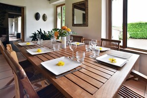 Ein Esstisch mit Tellern, Besteck und Gläsern, dazu ein Blumenstrauß mit gelben Blumen.