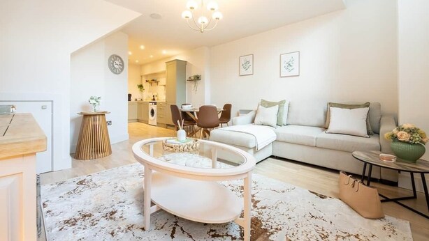 Un salon moderne avec un canapé, une table basse et un coin repas.