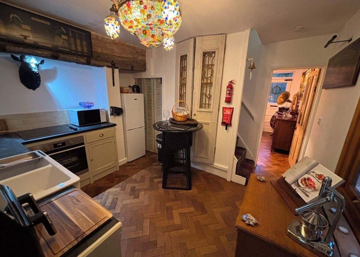 A kitchen with a microwave, oven, and a wooden countertop.