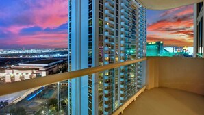 Un hotel di grattacielo con un balcone, che offre viste sulla città e un tramonto.