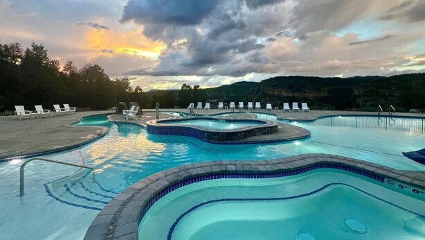A swimming pool with multiple sections and lounge chairs.