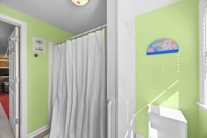 A bathroom with a shower curtain, a towel rack, and a wall-mounted towel rack. - Luxury Waterfront & Oceanfront Beach Paradise (North Topsail Beach)