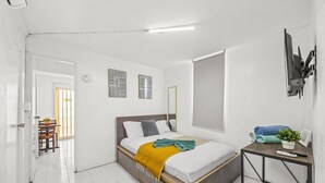Una camera da letto con un letto, un comodino e una TV a parete.