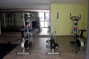 A gym with stationary bikes, weight machines, and a treadmill. - Design Apartment Facing Plaza Belén & Church - Historic La Candelaria & Rooftop (Bogotá)