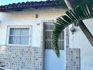A building with a tiled facade, a numbered door, and a window with metal bars. - Casa Gil: A Traditional House in Puerto... Vallarta, just a few blocks from bars and restaurants (Puerto Vallarta)