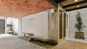 A modern interior with a concrete bench, a potted plant, and a textured floor. - El Pocito By Homirent  (San José de los Olvera)