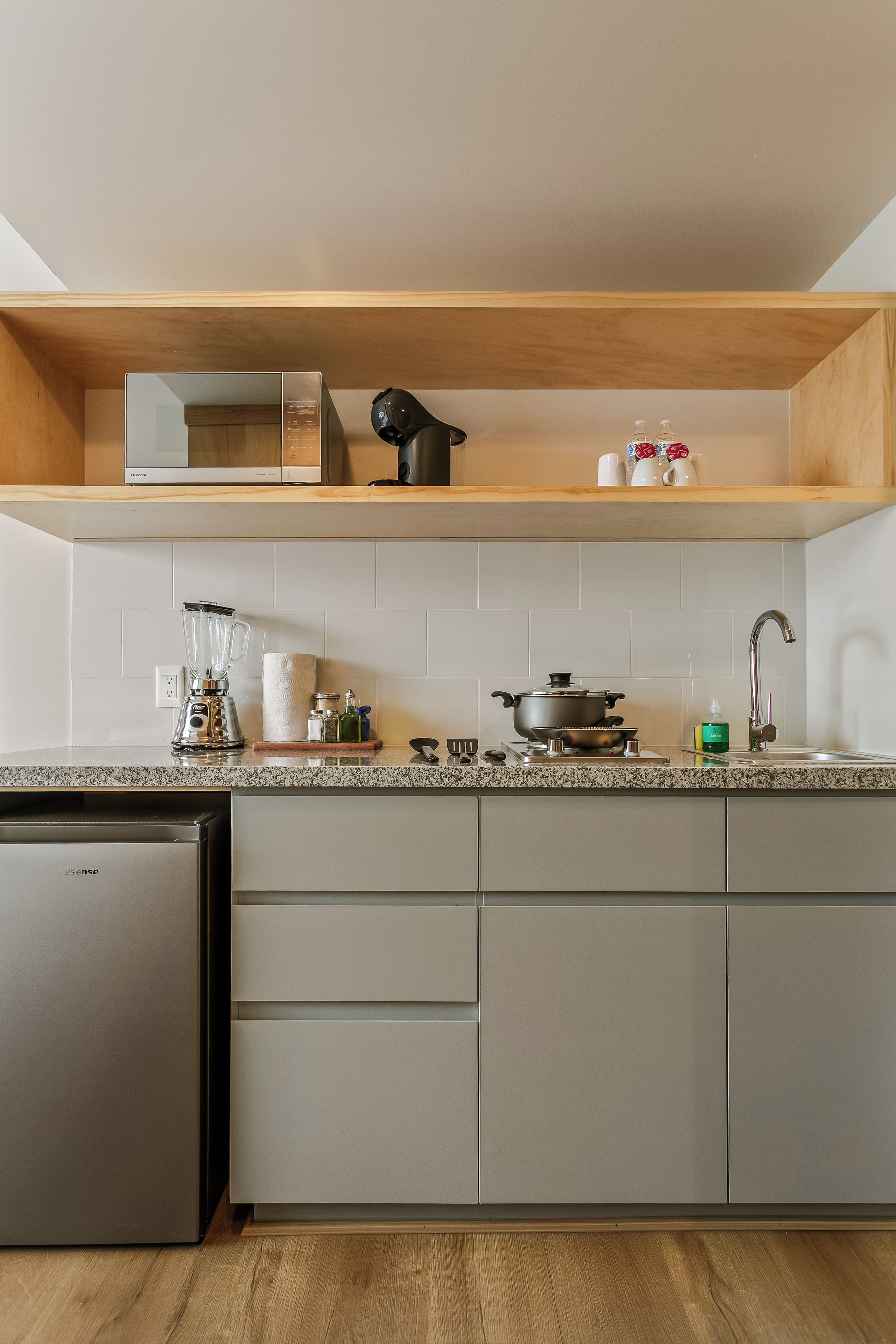 Eine moderne Küche mit Backofen, Spüle und einer Arbeitsplatte mit verschiedenen Küchenutensilien.