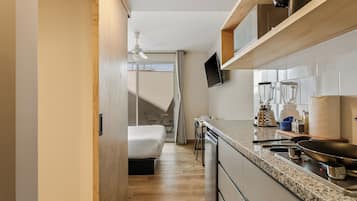 Una cocina compacta con horno integrado, microondas y cafetera.