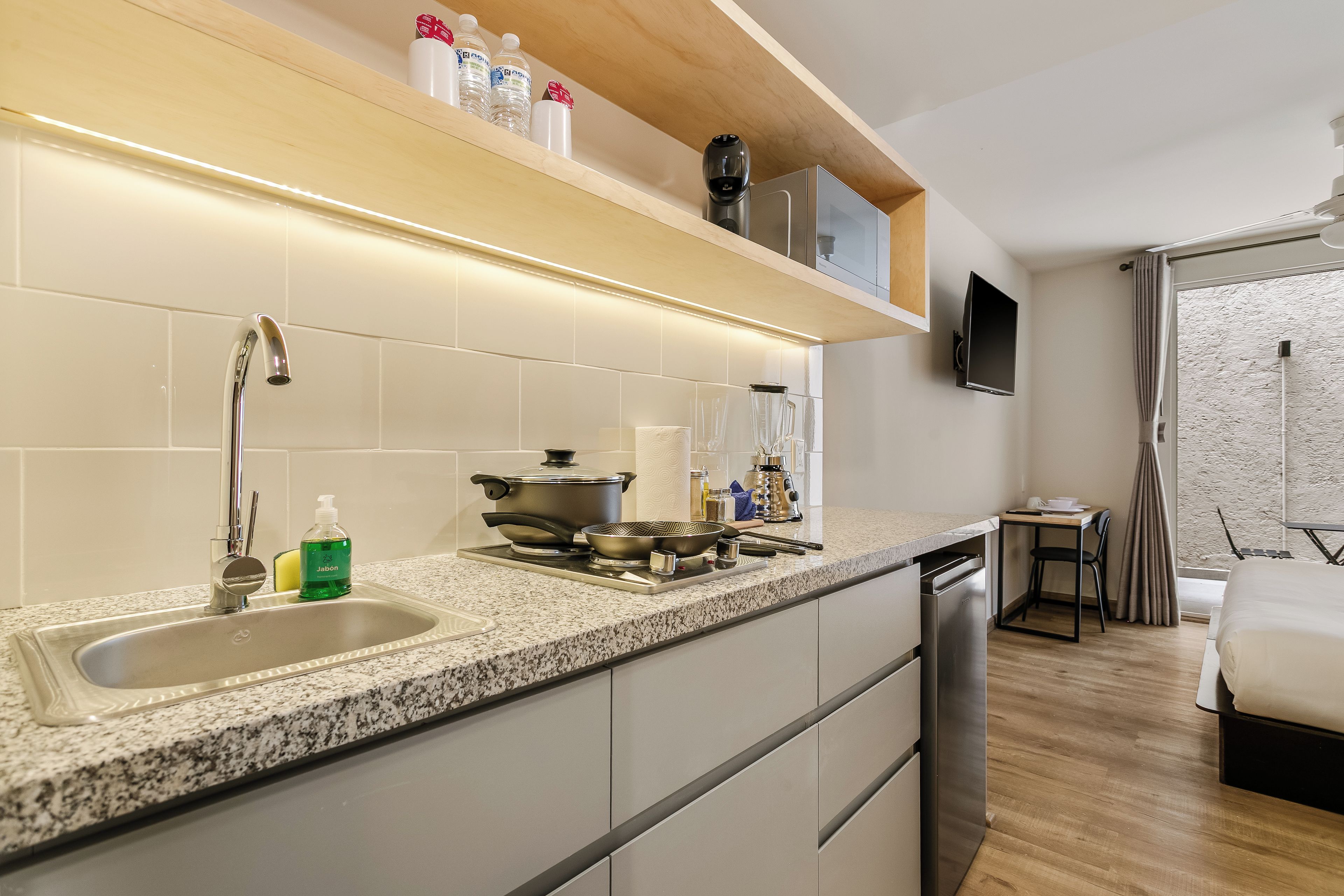 A modern kitchen with a granite countertop, stainless steel appliances, and a built-in dishwasher.