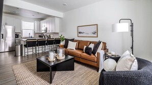 Een moderne woonkamer met een bank, salontafel en een lamp.