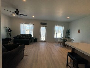 A spacious living area with a sofa, a dining table, and a ceiling fan. - New townhome in peaceful- friendly neighborhood with 3 bedrooms and 2.1/2 bath (Eagle Mountain)
