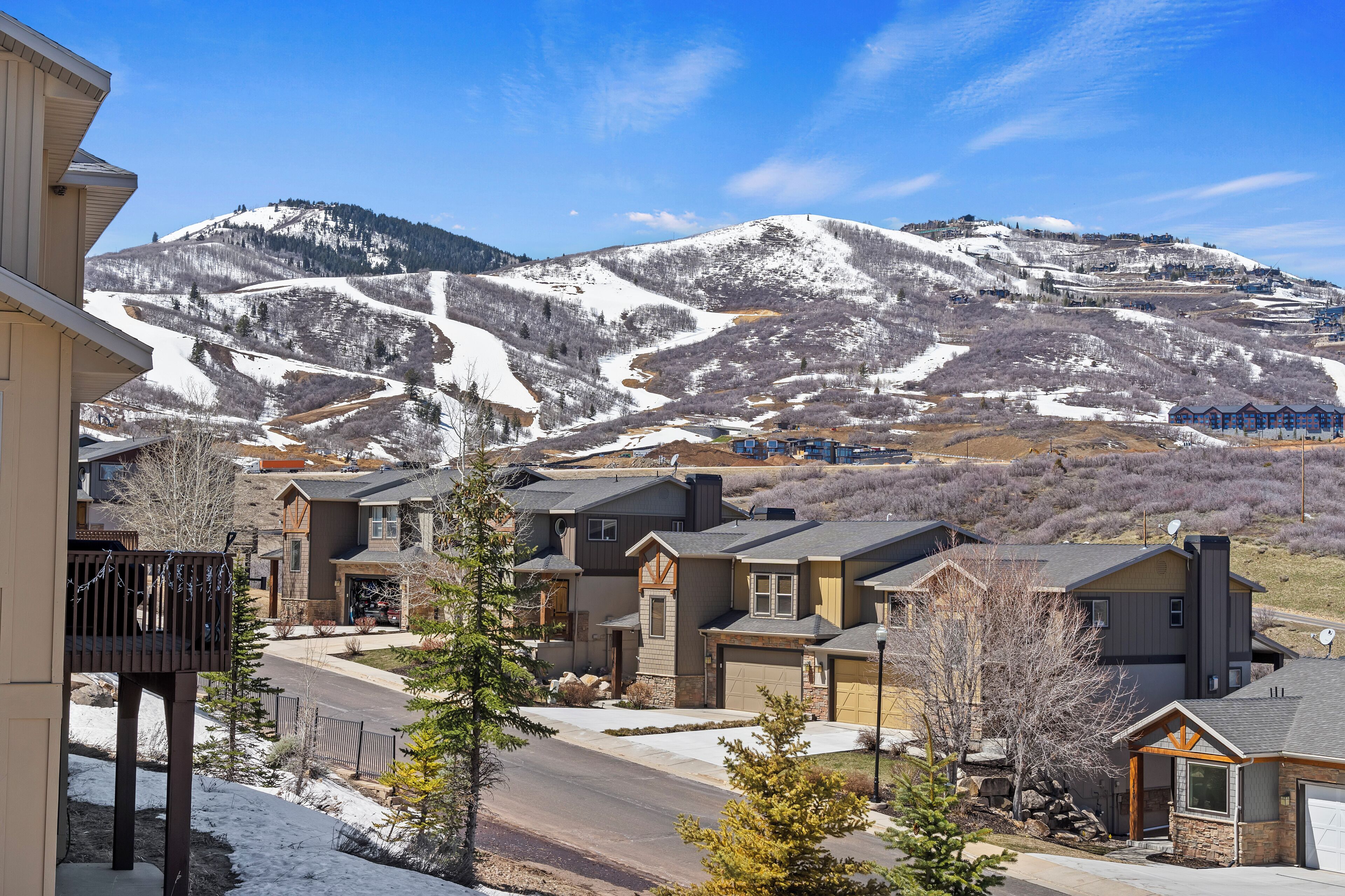 Un quartier résidentiel avec des maisons, une rue et une montagne en arrière-plan.