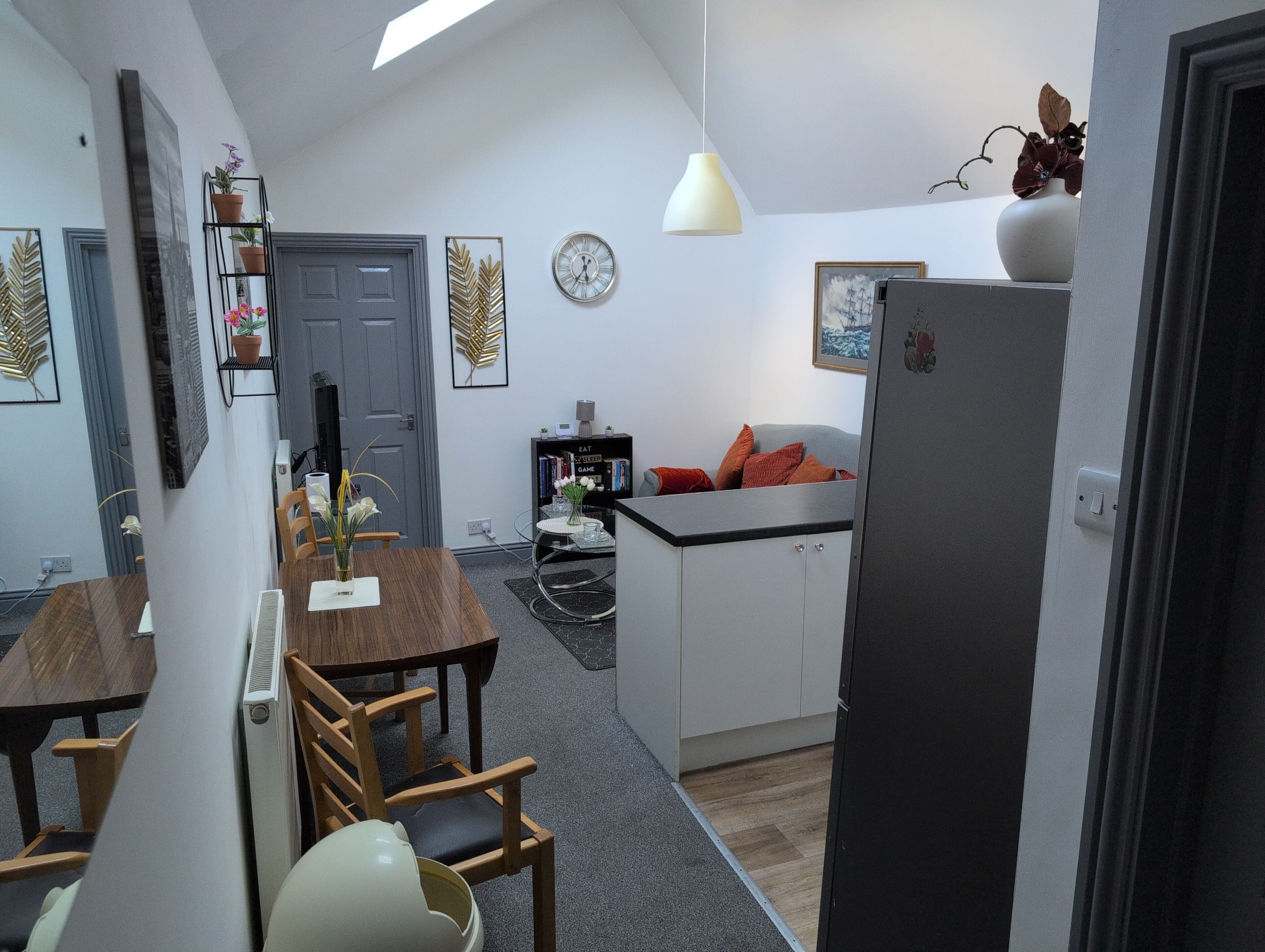 A compact living space with a dining area, kitchenette, and a small seating area.