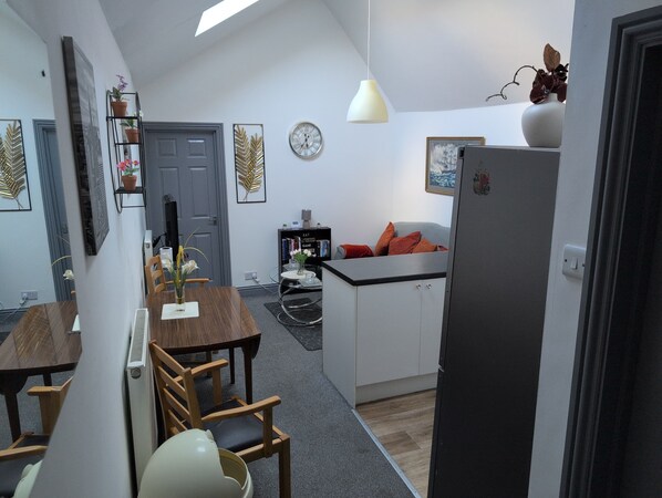 A compact living space with a dining area, kitchenette, and a small seating area.