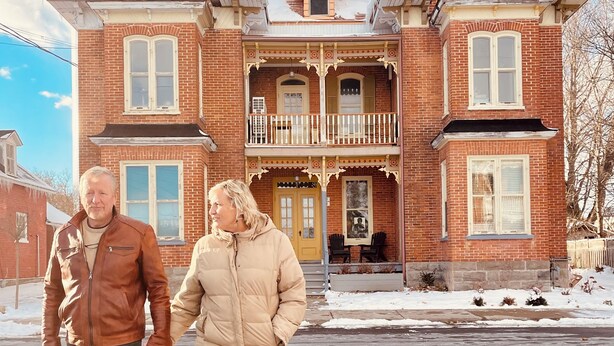 A large brick house with a balcony, a front door, and a driveway.