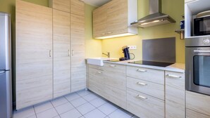 Une cuisine moderne avec des meubles en bois, une hotte en acier inoxydable et un four encastré.