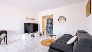 Un salon moderne avec un téléviseur à écran plat, un canapé, une table basse et un meuble pour téléviseur.