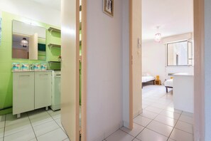Une chambre d’hôtel avec un lit, une table de chevet, un miroir et une fenêtre.