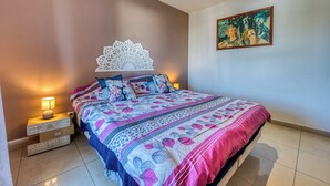 Ein Schlafzimmer mit einem Bett, Nachttischen, einer Wanddekoration und einem Gemälde.