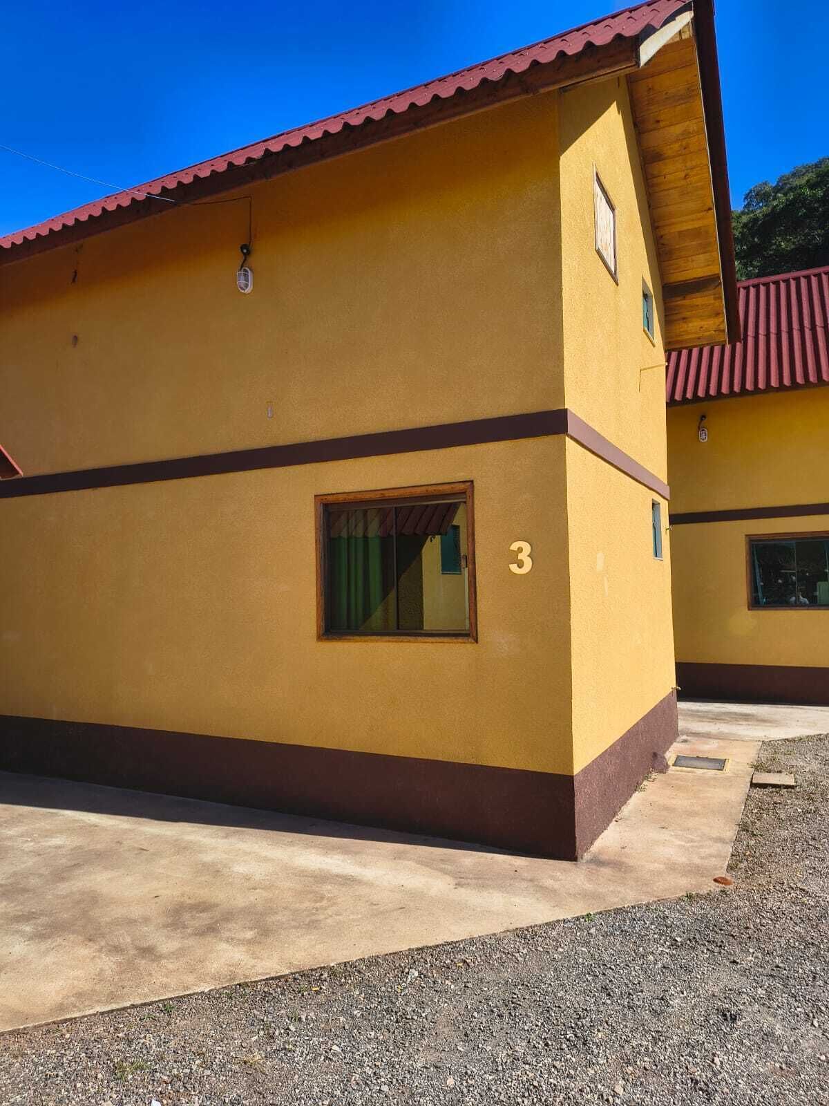 A yellow building with a red roof, a window, and a number '3' on the side.