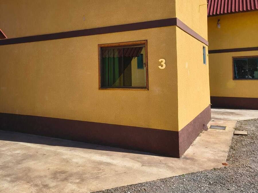A yellow building with a red roof, a window, and a number '3' on the side.