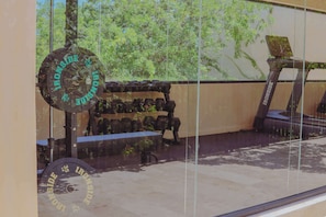 A gym with weightlifting equipment, including barbells and weight plates, and a treadmill. - 1st Flr Chic Jungle 1BR: Priv Pool, Steam & Gym (Tulum)
