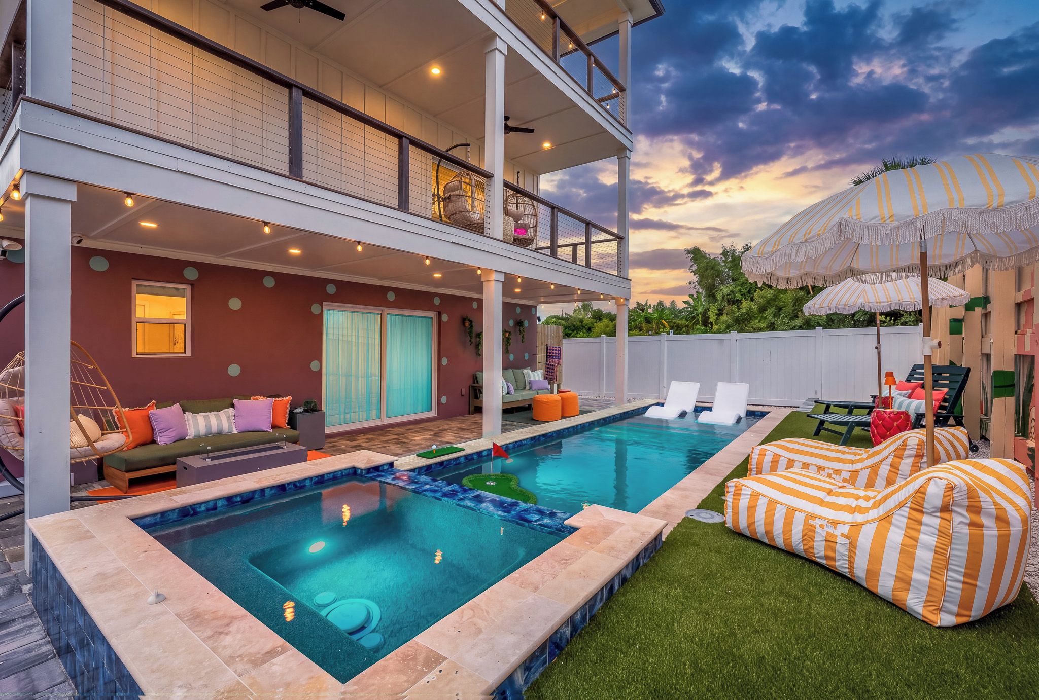 A two-story house with a swimming pool, outdoor seating, and a covered patio area.