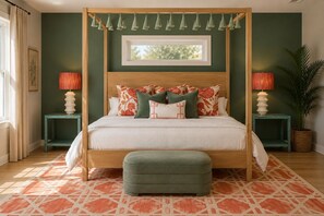 A four-poster bed with a canopy, a green ottoman, two nightstands with lamps, and a patterned rug. - Butler Beach | Heated Pool + Theater + Ocean Views (St. Augustine)