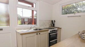 Una cocina con pileta, estufa, horno y ventana.