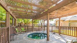 Un espace extérieur abrité comprenant une piscine, des sièges et une terrasse en bois.