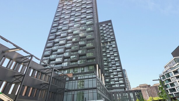 Ein hohes, modernes Hochhaus mit mehreren Balkonen und großen Fenstern.
