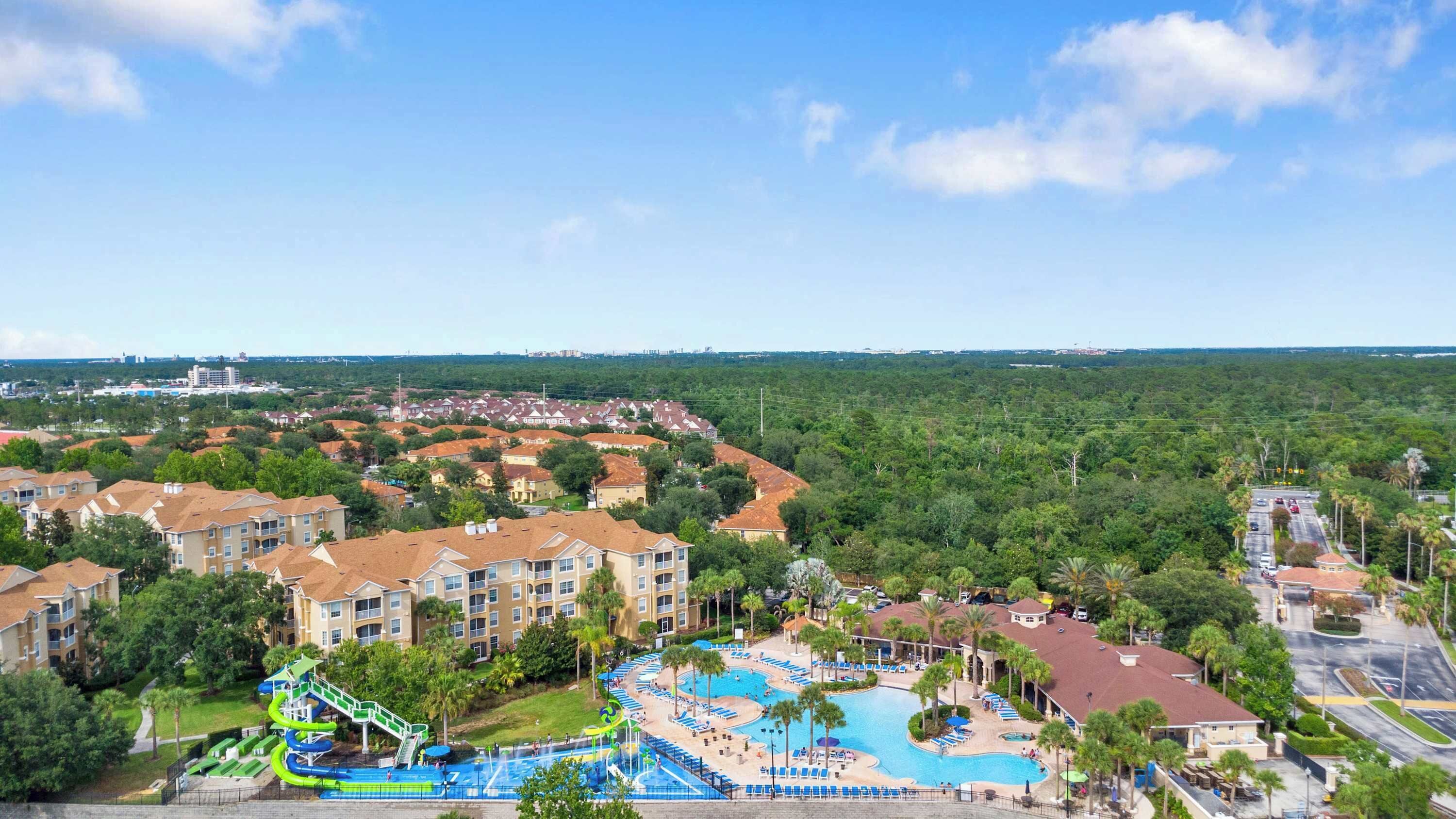 A resort with a swimming pool, a water park, and a view of the surrounding area.