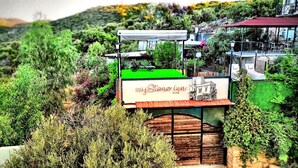 A sign for 'myStone Inn' with a view of a mountainous landscape and a building with a red roof.