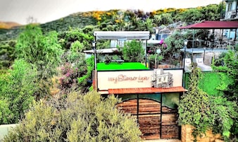 Un cartel de 'myStone Inn' con vistas a un paisaje montañoso y un edificio de techo rojo.