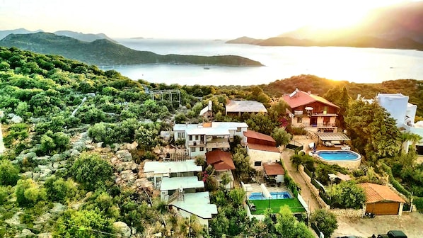 Una propiedad costera con varias edificaciones, una piscina y vista al mar.