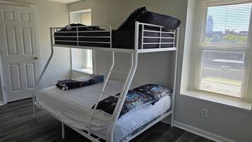 Una cama litera con ventana, puerta y toma de corriente.