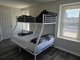 Una cama litera con ventana, puerta y toma de corriente.