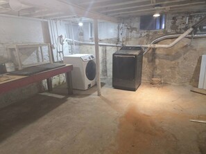 Une buanderie équipée d’un lave-linge, d’un sèche-linge et d’un établi.