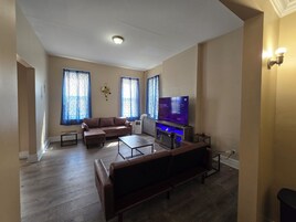 Una sala de estar con sofá, televisor y chimenea.