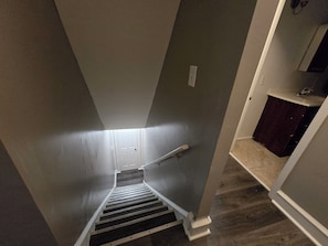 A stairway with a handrail leading to a landing. - Charming 6 Bedroom & 4 Bath Home Near Philadelphia (Camden)