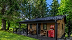 A wooden cabin with a porch, seating area, and a Coca-Cola refrigerator. - Coca-Cola Cabin @Fire Mountain Estate & Club. Endless views, Fire Pit, Jacuzzi! (Scaly Mountain)