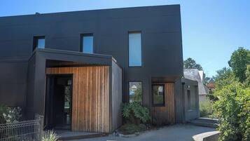 Een modern gebouw met een plat dak, grote ramen en een houten entree.