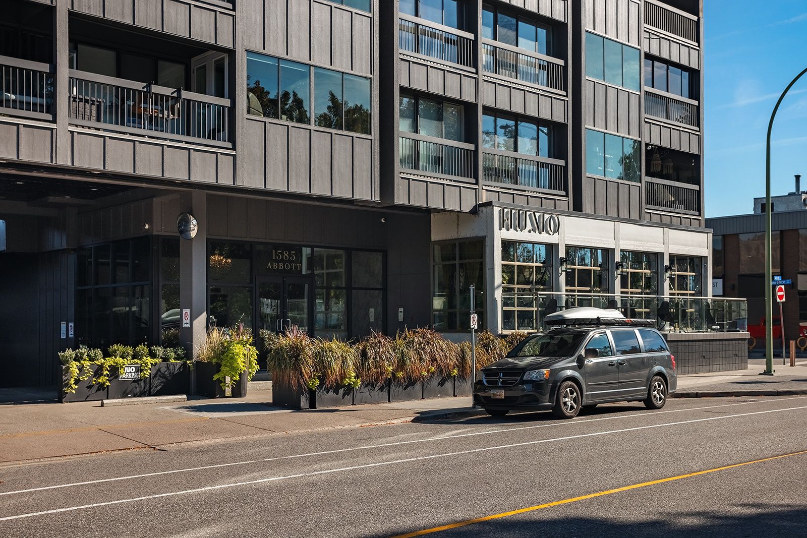 A modern building with a storefront labeled 'HUMMO' and a vehicle parked in front.