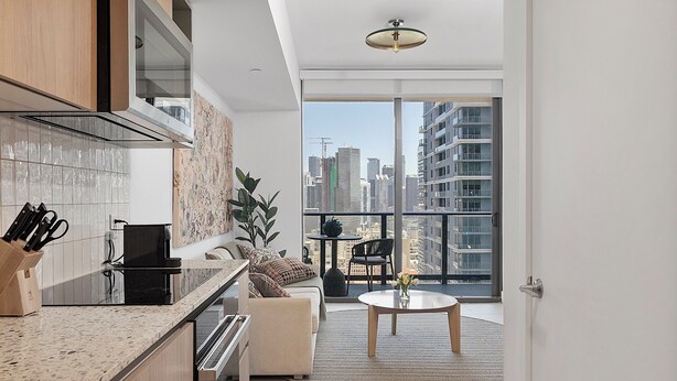 Una cocina moderna con un ventanal grande, una zona de comedor con una mesa redonda y vistas a la ciudad.
