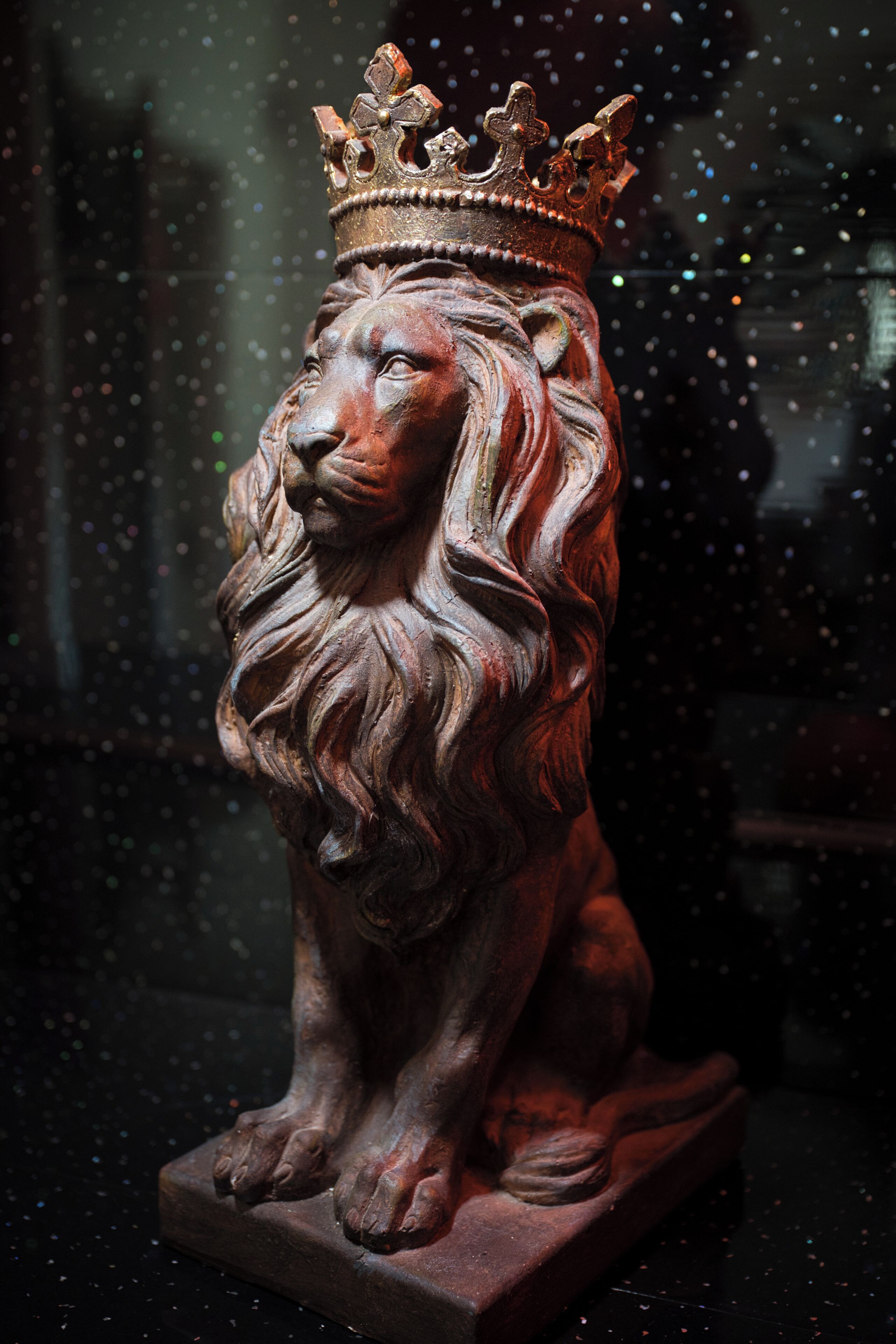 A wooden statue of a lion with a crown.