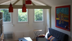 Une pièce avec un canapé, une table et une fenêtre donnant sur un paysage verdoyant.